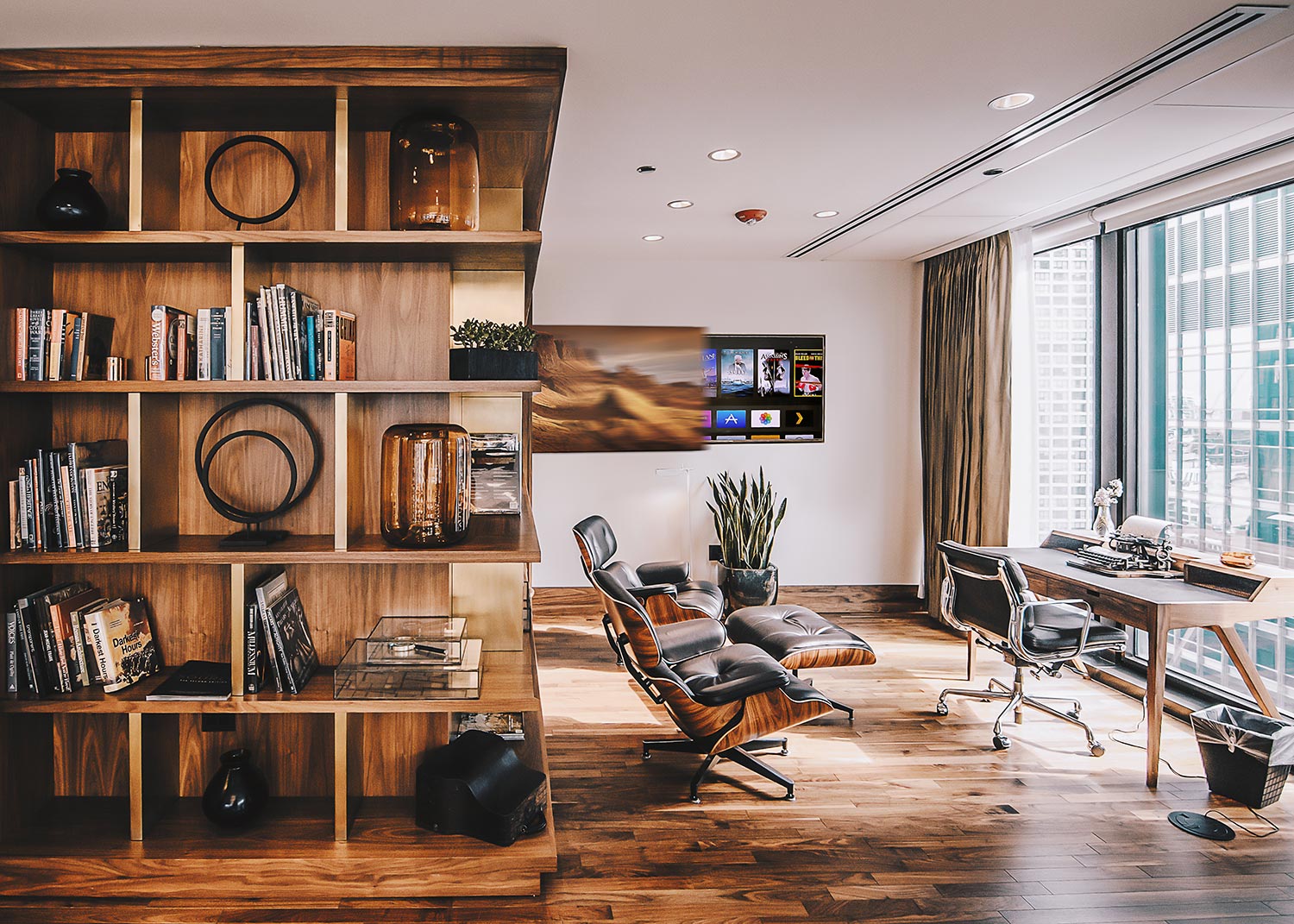 Home office with wood shelving and lounge chair near window