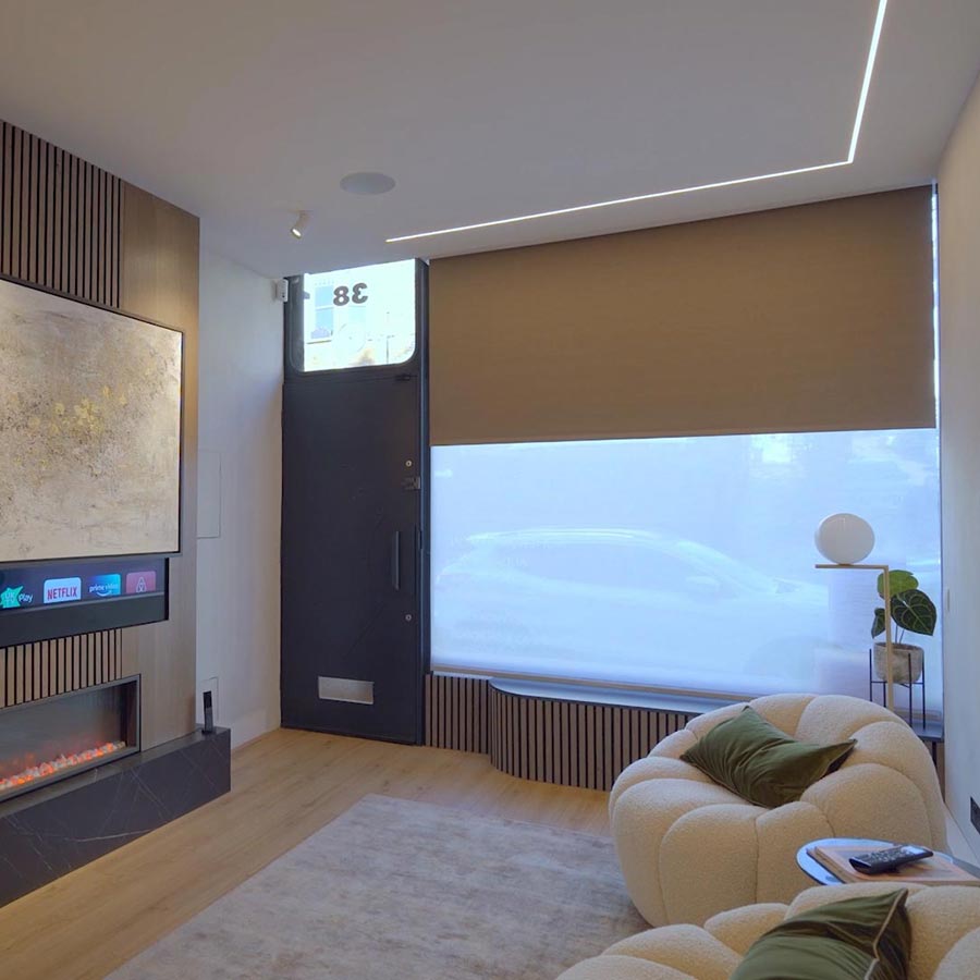 Motorised shades lowering over large windows in a bright beachfront living room