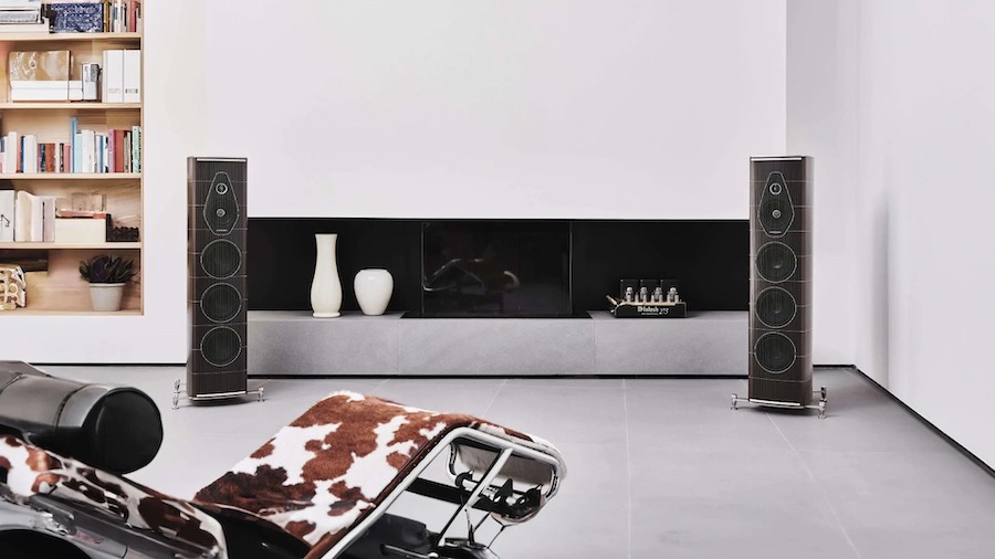 A pair of high-end audio speakers flank a fireplace in a modern home. 